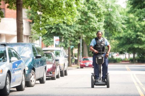 Officer riding a segway motor vehicle device down a street